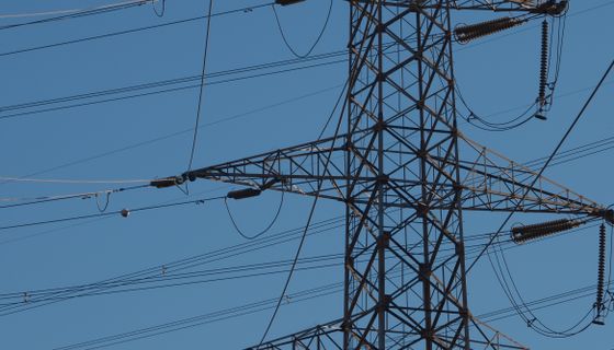 High-voltage power lines against a blue sky
